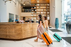 Traveler friends arriving at a hotel with luggage