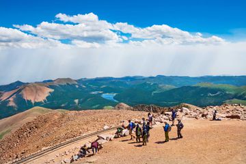 People hiking on top of the Pikes Peak mountain in Colorado on summer day.