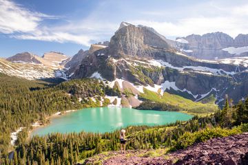 A young woman hiking through Glacier National Park in Montana on a beautiful summer day.
