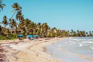 White sand beach with surfers in Puerto Rico